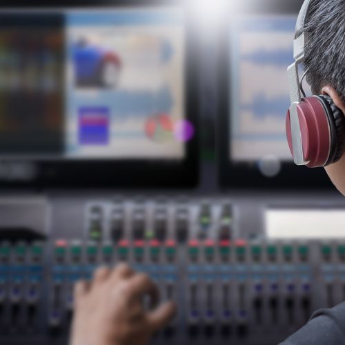 Director with headphone working video sound mixing console studio