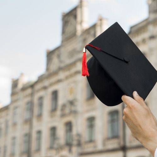 Graduation concept with student holding hat